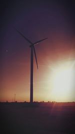 Wind turbines on field at sunset