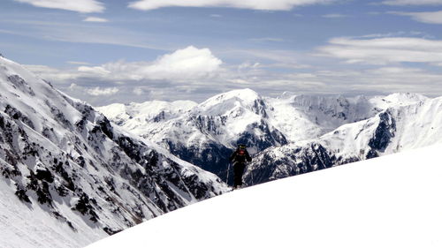 Mature woman skiing of snowcapped mountains against sky