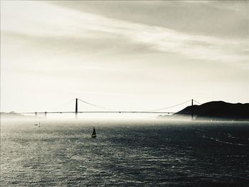 Bridge over sea against sky during foggy weather