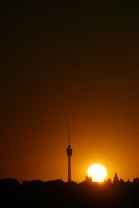 Silhouette of communications tower at sunset