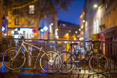 Bicycles parked on street in city at night