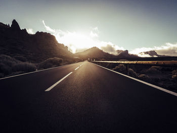 Empty road along landscape against sky