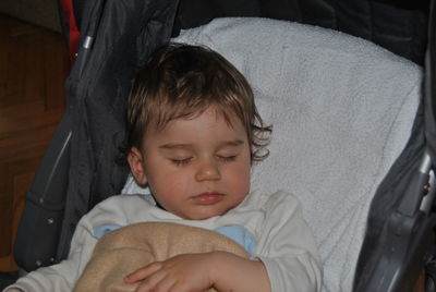 Cute baby boy sleeping in stroller at home