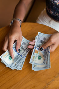 Close-up of human hand holding cup on table