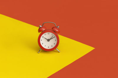 Close-up of clock on yellow background