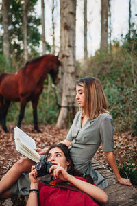 Young woman photographing in forest