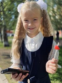 Portrait of happy girl holding camera