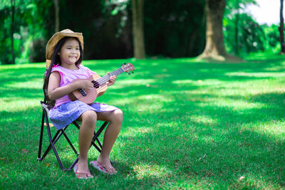 Full length of smiling girl playing on grass