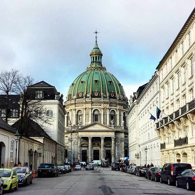 building exterior, architecture, built structure, religion, church, place of worship, car, street, sky, spirituality, city, transportation, cathedral, land vehicle, incidental people, road, dome, travel destinations