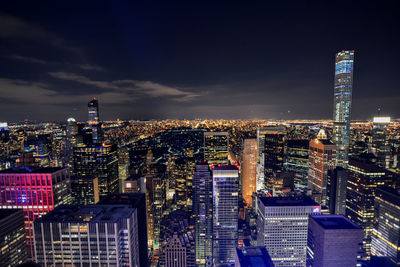 Illuminated cityscape against sky at night