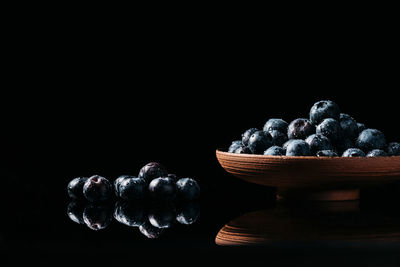 Close-up of fruits on table against black background