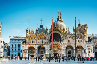 People in front of church against clear blue sky