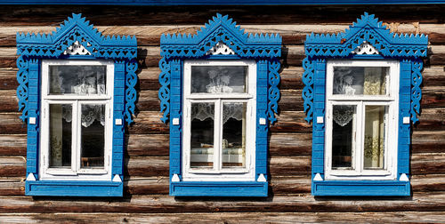 Old wooden windows with carved architraves. log facade of typical rural russian house.