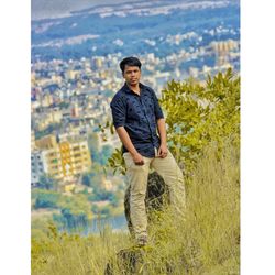Portrait of young man standing against plants