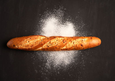 Close-up of bread on table against black background