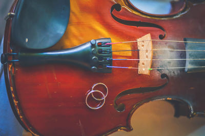 Close-up of wedding rings on violin