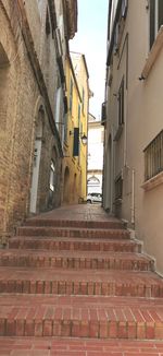 Low angle view of alley amidst buildings in city