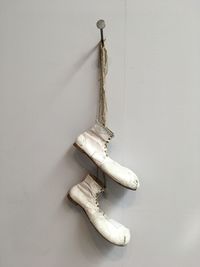 Shoes hanging on white wall