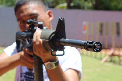 Close-up of man aiming gun