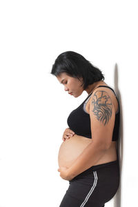 Side view of woman standing against white background