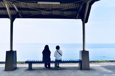 Rear view of people looking at sea against sky