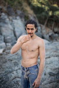 Portrait of young man standing on rock