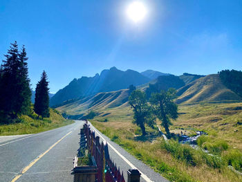 Road leading towards mountains against sky