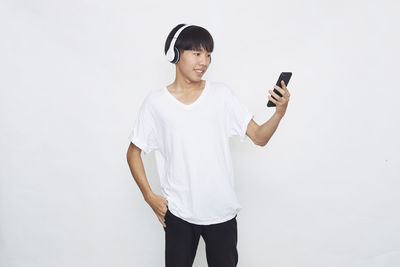 Full length of man using smart phone against white background