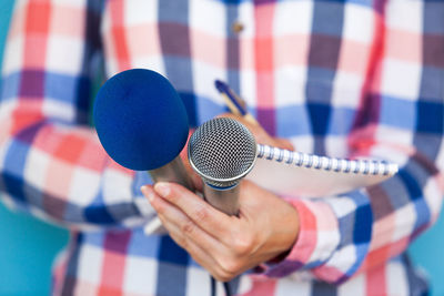 Close-up midsection of person with book holding microphones