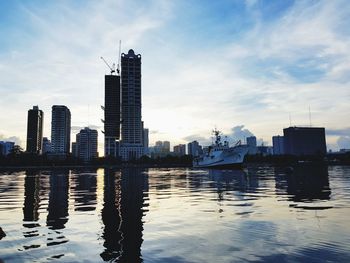 Sea and buildings in city against sky