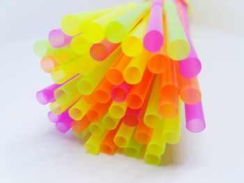 Close-up of colorful drinking straws over white background