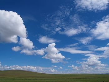 Scenic view of field against blue sky