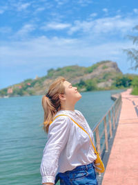 Woman standing in sea against sky