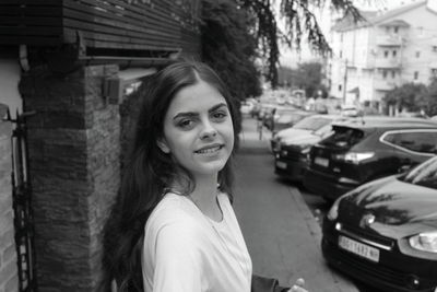 Portrait of smiling young woman in city