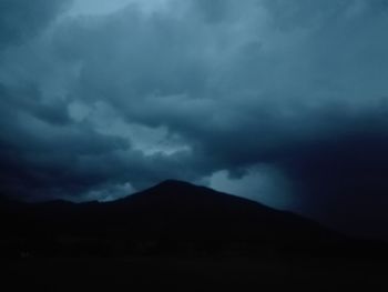 Scenic view of silhouette mountain against dramatic sky