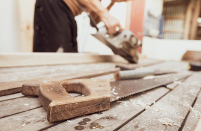 Midsection of carpenter working on wood