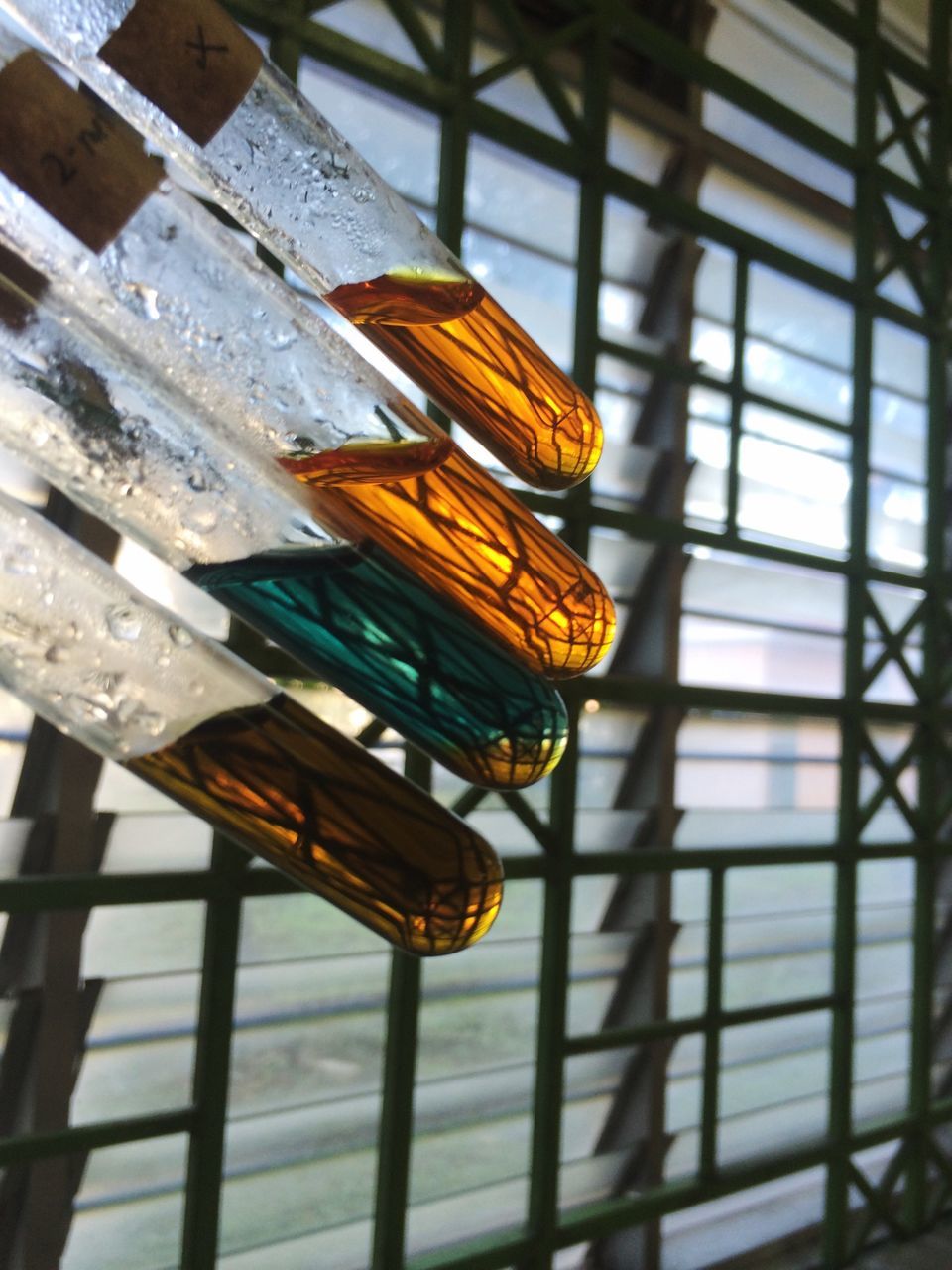 indoors, window, low angle view, built structure, architecture, close-up, glass - material, yellow, metal, no people, day, reflection, railing, pattern, hanging, sunlight, still life, transparent, home interior, wood - material