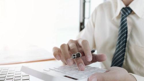 Midsection of man using laptop on table