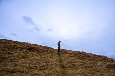 Woman standing on landscape against sky