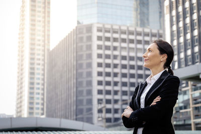 Full length of woman standing against buildings in city