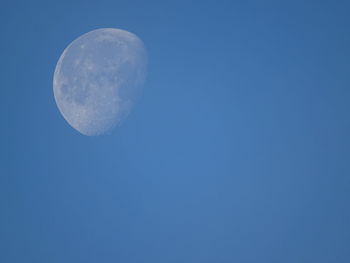 Low angle view of moon against blue sky