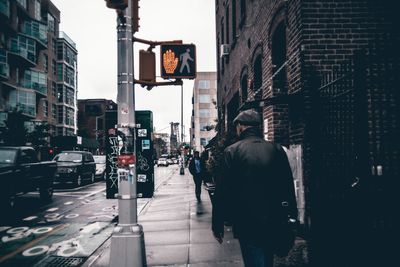 Rear view of woman walking on city street