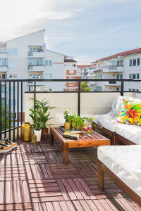 Chairs and table in balcony against sky