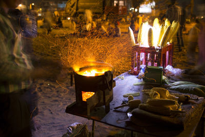 Blurred motion of man preparing corn on bonfire