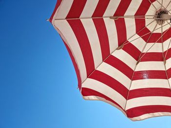 Low angle view of flag against clear blue sky