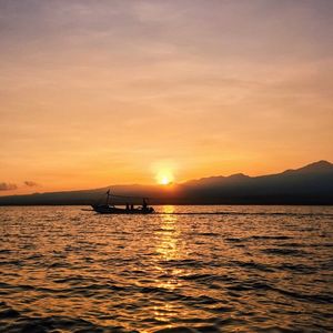 Boat sailing in sea at sunset