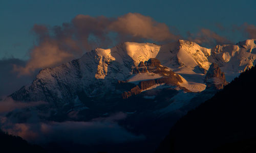 Scenic view of snow covered mountains against sky during sunrise