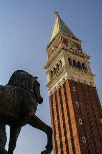 Low angle view of statue by san marco campanile