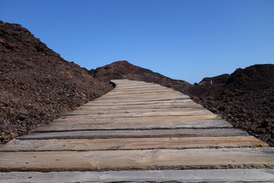 Low angle view of steps against clear blue sky