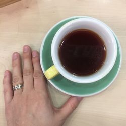 Close-up of woman and coffee cup on table